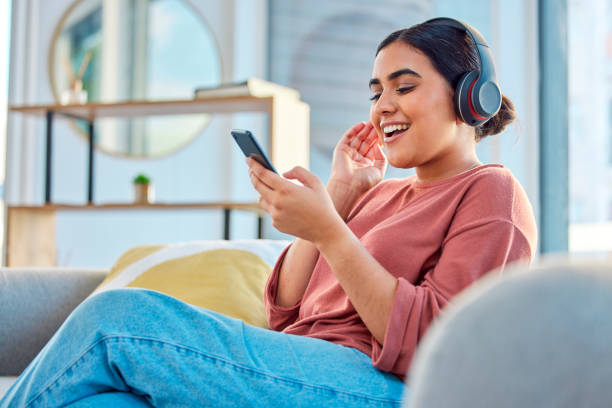 happy-woman-headphones-and-smartphone-in-living-room-on-social-media-app-audiobook-or-radio.jpg